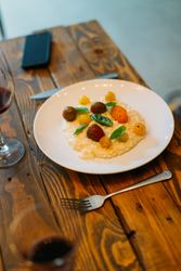 Risotto on wooden table with heirloom tomatoes and basil