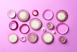Flat lay composition with red onion rings on color background