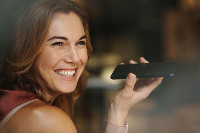 Portrait of a smiling woman holding a phone in her hand