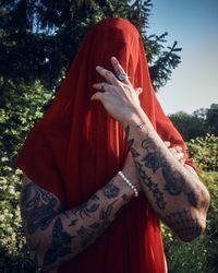 Tattooed male with red sheet on his head