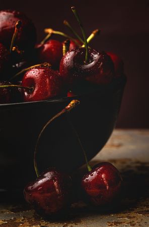 Juicy red cherry in bowl on rustic surface