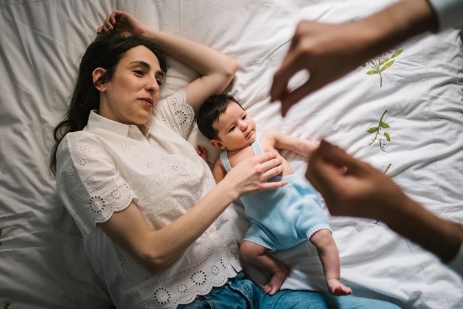 Mother and baby lying on bed
