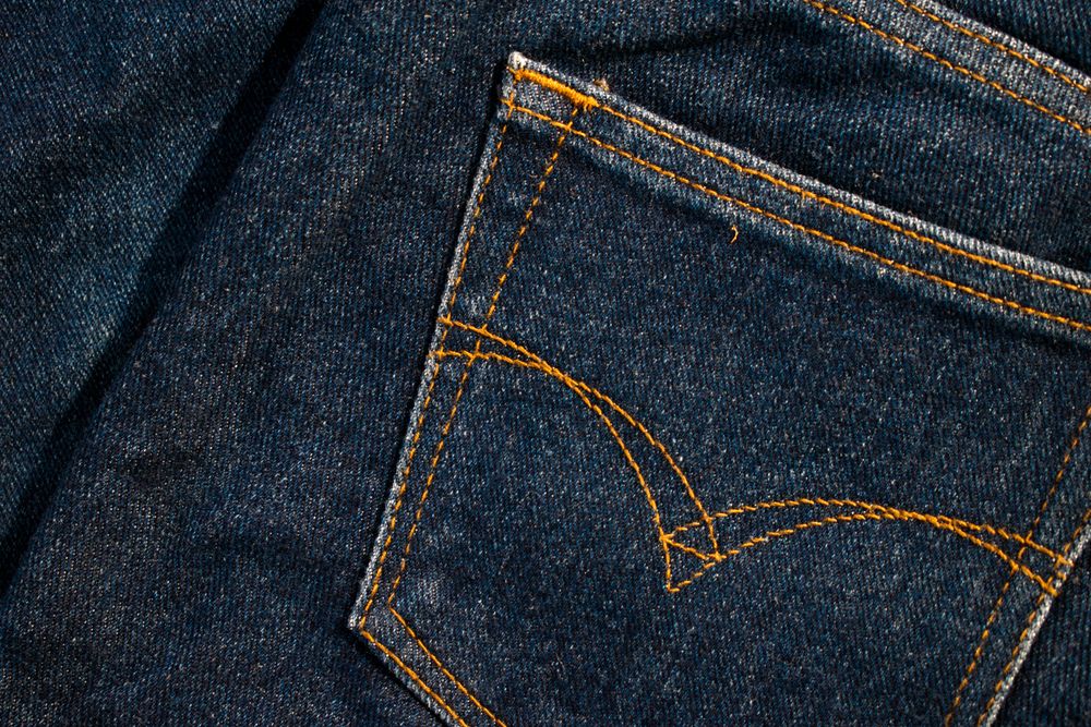 Close up Back pocket of navy blue jeans fabric texture background