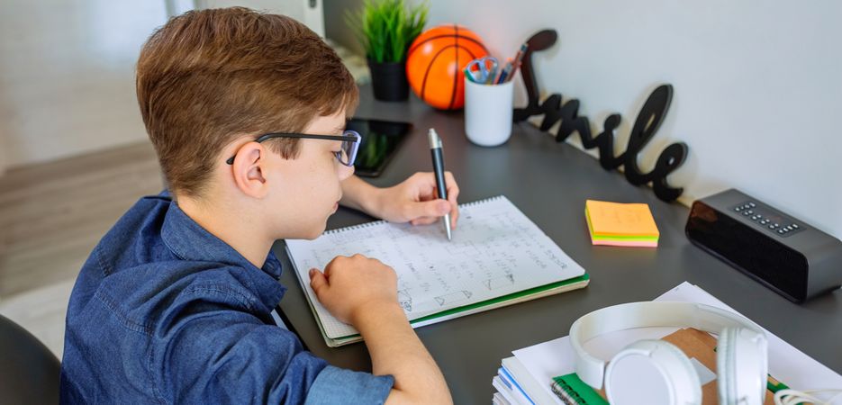 Left handed teenager doing homework in his bedroom