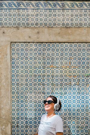 Cheerful casual woman in sunglasses standing on city street