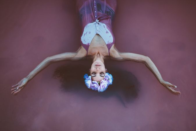 Woman with wreath lying in water