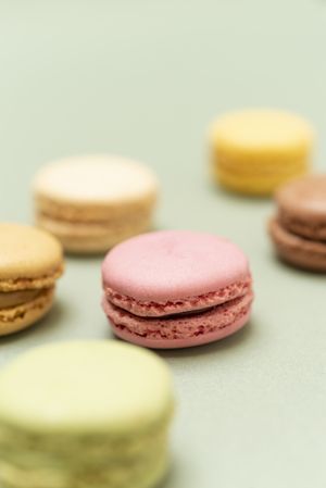 Pastel colored macaroons over a green background