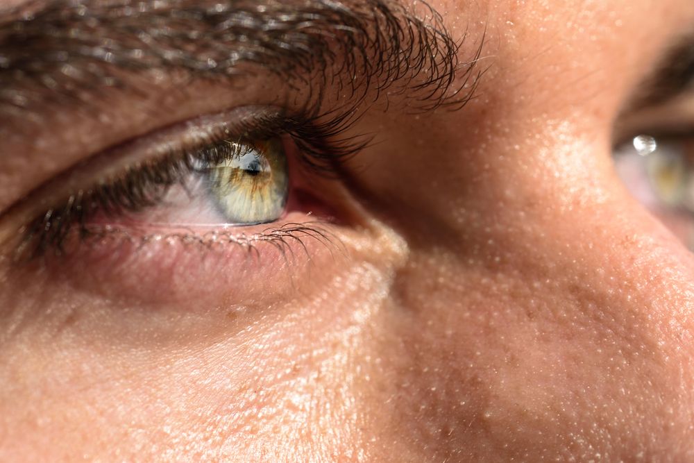 Man’s green eyes in the sun