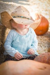 Adorable Baby Girl with Cowboy Hat at the Pumpkin Patch.