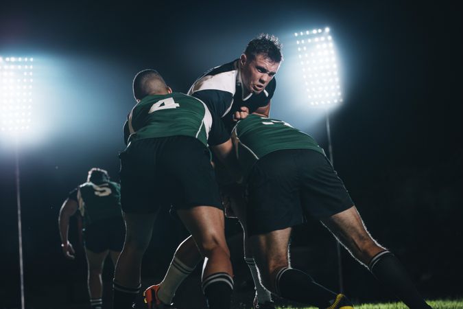 Rugby players fighting for the ball during the night game