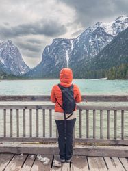 Anonymous traveler admiring mountains and lake from pier