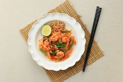 Top view of spicy pad Thai on placemat
