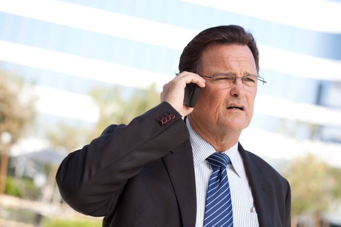Concerned Businessman Talks on His Cell Phone
