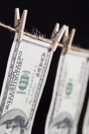 Hundred Dollar Bills Hanging From Clothesline on Dark Background