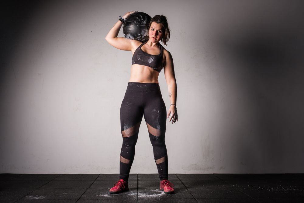 Woman lifting medicine ball in gym