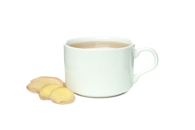 Cup of tea and ginger slices, isolated on plain background