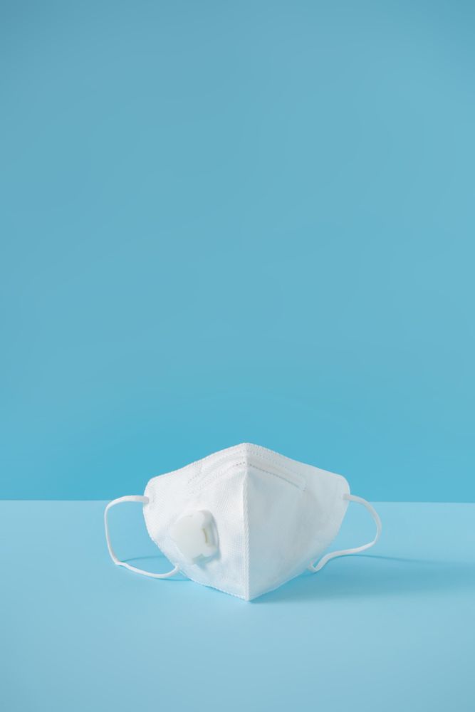 Medical mask on pastel blue background
