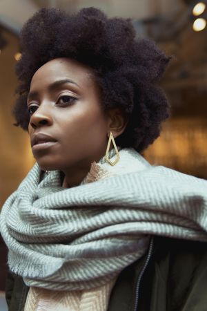 Portrait of Black woman in gray scarf looking away