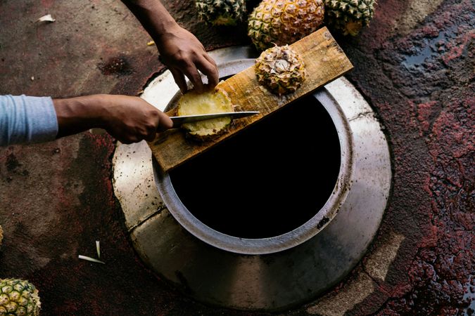 Casual man cutting pineapple