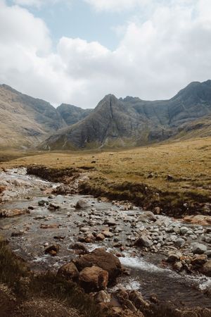 Picturesque view of stream by high mountains