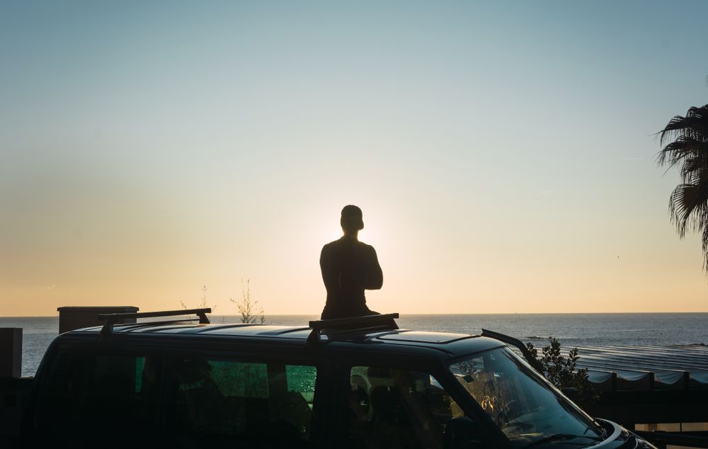 Man enjoying the sunrise in his camped van