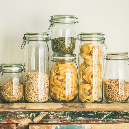 Pasta, grains, and beans stored in glass jars in a pantry