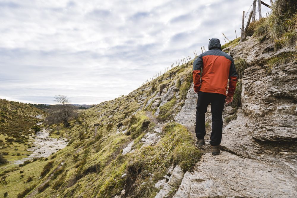 Man walking on hill near valley