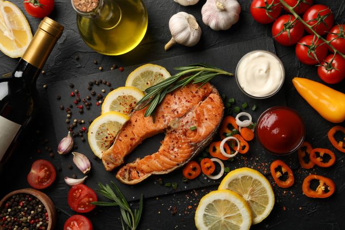Composition with tasty grilled salmon on dark background, top view