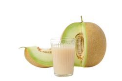 Sliced fresh melon with a glass of juice, isolated on plain background