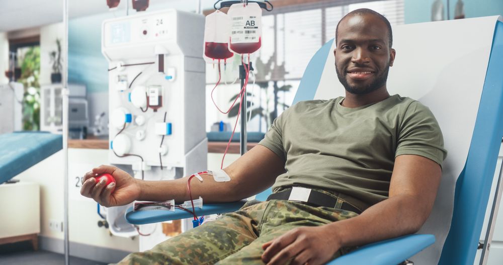 Black Male Army Soldier Donating Blood For Injured Comrades In Military Hospital.