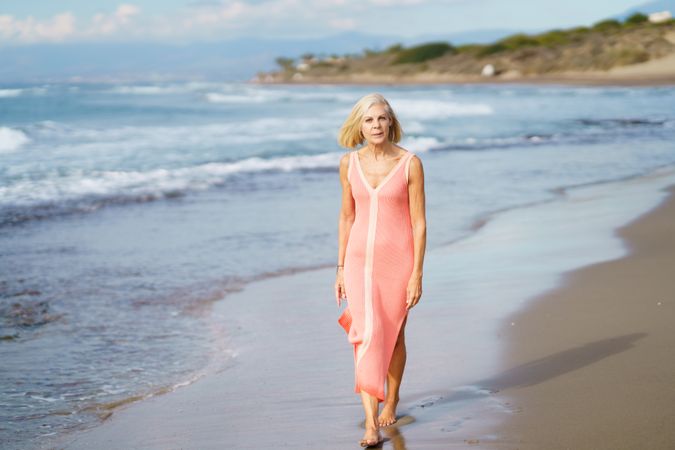 Older woman walking calmly along the coast