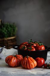 Ripe fresh tomatoes in pot on table