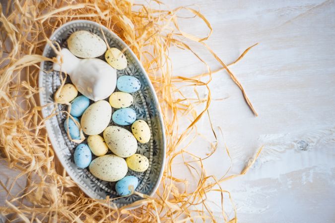 A bowl of Easter eggs surrounded with hay