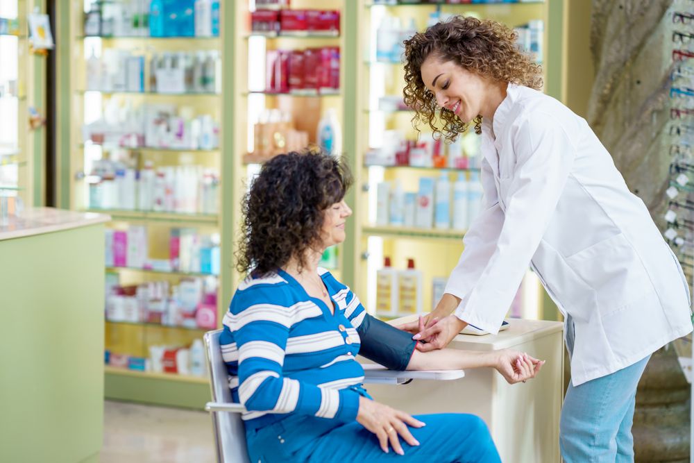 Female medical worker taking blood pressure of patient