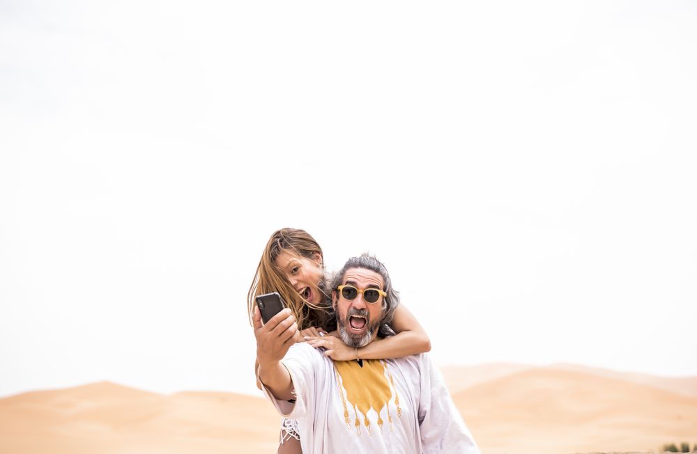 Laughing couple taking selfie on exotic terrace