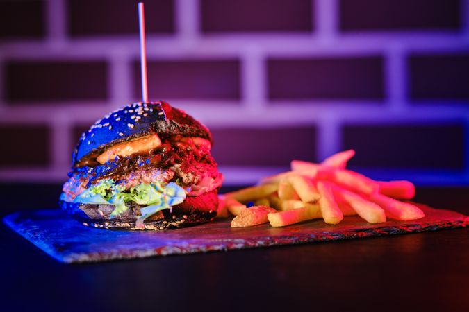 Delicious hamburger and fried potato on board