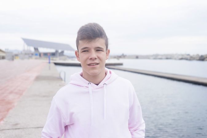 Young teenager walking on pier while looking away