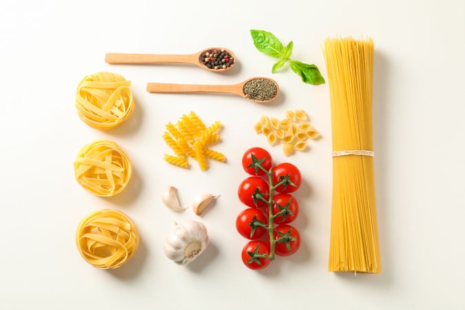 Flat lay composition with pasta ingredients on bright background, space for text