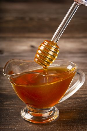 Honey in glass bowl on the table.