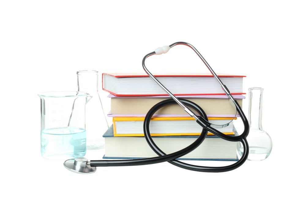 Books, stethoscope and flasks isolated on background