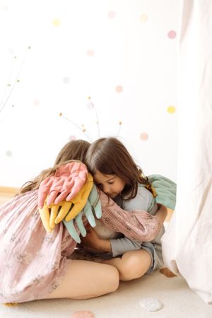 Happy kids in colorful wings hugging each other