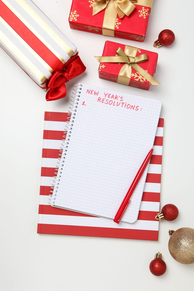 Gift boxes and notepad with text on light background, top view