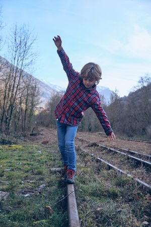 Boy walking on railroad in nature