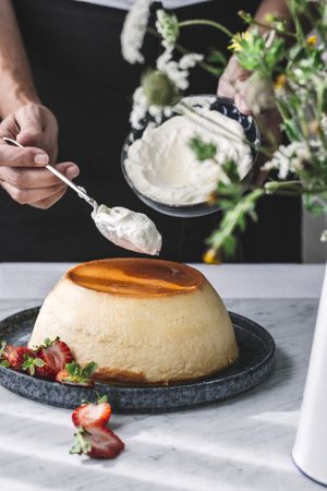 Hand putting cream on flan
