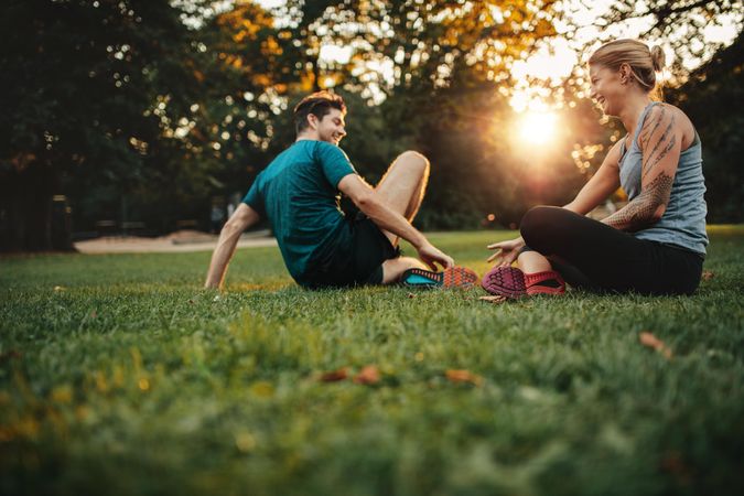 Happy fit young couple exercising in park