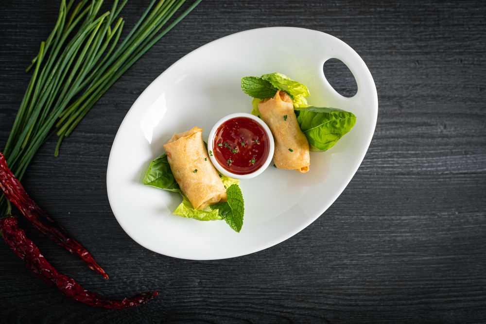 Vietnamese rolls with sweet chili on glass plate