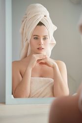 Calm woman in towel on head in bathroom