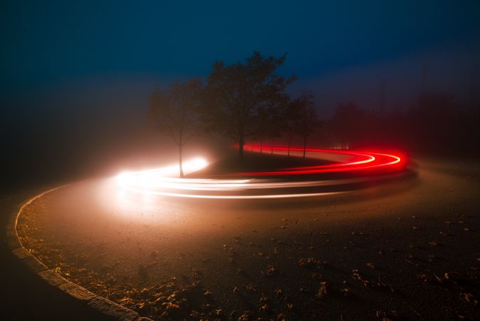 View of abstract shines on road between fog at night