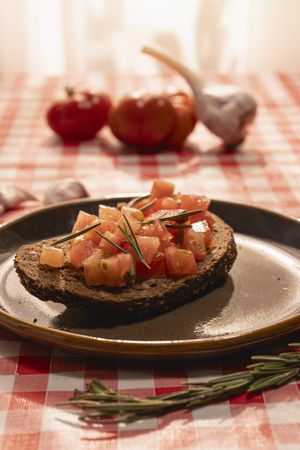 Bruschetta with tomatoes and rosemary on rustic table