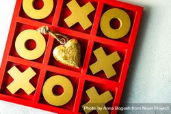 St. Valentine day card concept with golden heart ornament in center of tic-tac-toe game 5oDqB8